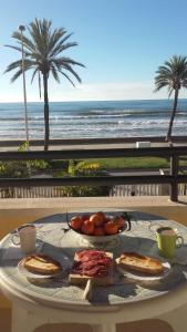 库尼特Apartamento Primera Linea de Mar, Cunit的海滩上一张桌子和一盘食物