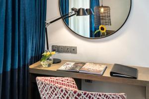 班加罗尔班加罗尔公园酒店的一张带镜子的桌子、一盏灯和一本书