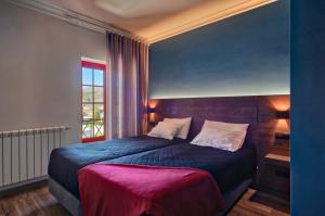 拉博雷鲁堡Alojamento Local - Miradouro do Castelo的一间卧室配有一张大床和紫色毯子