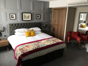 利明顿温泉天使酒店的一间卧室配有一张带黄色枕头的大床