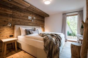 圣马蒂诺-因巴迪亚Les Dolomites Mountain Lodges的卧室设有木墙和一张大床