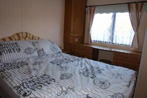 文戈热沃Domek na półwyspie Kal的一间卧室配有一张床、一张书桌和一个窗户。