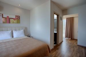 海若克利欧埃瑞尼酒店的一间卧室设有一张大床和一个窗户。