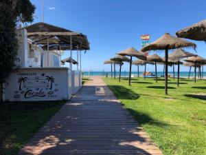 莫切El Balcón de Rosita的海滩上带草伞的人行道