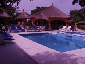 ToubakoutaB & B Mariamacounda的一个带椅子的游泳池和一个凉亭