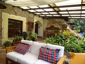 危地马拉安地瓜卡萨圣罗萨精品酒店的庭院内一张带两个枕头的白色沙发