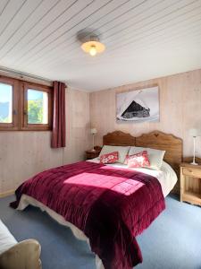 莱热Chalet Le Renard Du Lac的一间卧室配有一张带红色毯子的大床