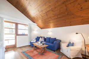 洛伊塔施奥瑟尔施奈德公寓的客厅配有蓝色的沙发和桌子