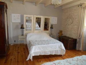 CresséLe vieux Prieuré的卧室配有一张白色的大床,铺有木地板