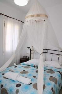 塞里福斯Anemoessa Studios的一间卧室配有一张带天蓬的床