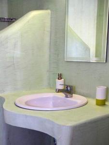 塞里福斯Anemoessa Studios的浴室设有粉红色的盥洗盆和镜子