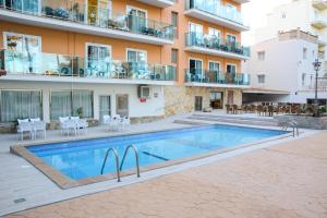 埃尔阿雷纳尔Hotel Costa Mediterraneo的大楼前带游泳池的公寓