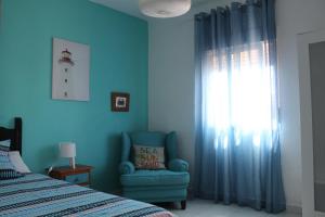 阿亚蒙特Aloja Puerto Deportivo的卧室配有床、椅子和窗户。