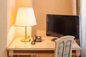 塞巴特阿尔贝克奥古斯特维多利亚别墅酒店的一张桌子,内配电视、灯和灯