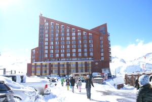 巴耶内瓦Departamento Valle Nevado Ski Resort Chile Ski in - Ski out的一群人在一个建筑物前的雪中行走