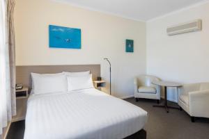 沃纳姆堡最佳西方奥尔德海洋汽车旅馆的酒店客房,配有白色的床和椅子