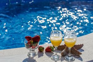 特罗吉尔Holiday Villa Nostra的池畔桌子旁的两杯葡萄酒和草莓