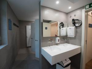 里斯本room00 Lisboa Hostel的浴室设有白色水槽和镜子
