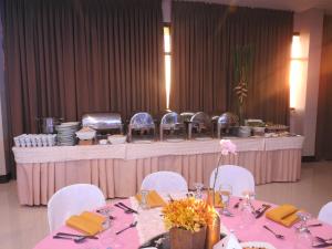 马尼拉莱斯登西亚精品公寓式酒店的一张带白色椅子的桌子和一张粉红色的桌布