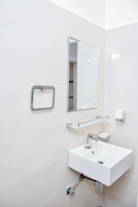 高尔Saman Beach Guest House的白色的浴室设有水槽和镜子