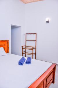 高尔Saman Beach Guest House的一间卧室配有一张带2条蓝色毛巾的床