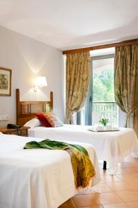努瓦洛斯石头修道院酒店的酒店客房设有两张床和窗户。