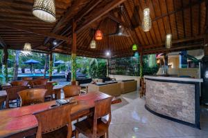 蓝梦岛Taos House Nusa Lembongan by Best Deals Asia Hospitality的一间带桌椅的餐厅和酒吧