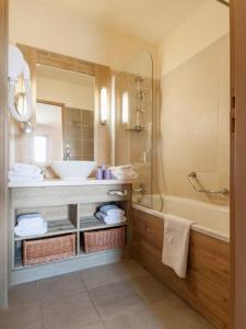 福勒恩Flaine prime ski in, ski out Apartment的一间带水槽、浴缸和镜子的浴室