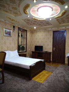 撒马尔罕SHAHNOZA GRAND的一间卧室设有一张大床和大型天花板。