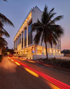 德瓦纳哈利-班加罗尔Shivas Galaxy Hotel的街道前有棕榈树的建筑