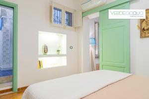 马里内拉Verdeacqua Holiday House的一间卧室设有一张床和一个绿门