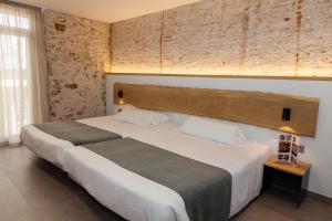 巴塞罗那巴黎旅馆的卧室配有一张白色大床