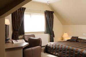 伊赫特赫姆沙龙德韦德酒店的卧室配有床、椅子和窗户。