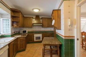 加苏莱斯堡Casa GaLuz, entre la Sierra y el Mar的厨房配有木制橱柜、桌子和水槽。