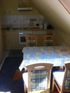 Strukkamp auf FehmarnLetztes-Haus-vorm-Wasser-1的厨房配有桌椅和桌子。