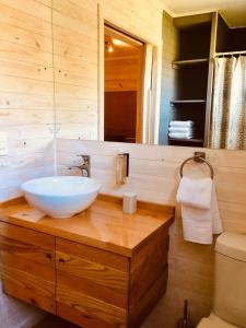 潘吉普伊Amukan Lodge的木制柜台上带白色碗水槽的浴室