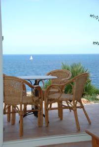 Cala MendiaResidencial Playa Mar的一组椅子和一张桌子,位于一个享有海景的庭院