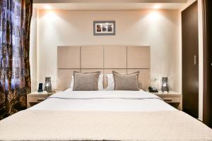 雅典雅典之路酒店的卧室配有一张带白色床单和枕头的大床。