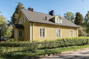 坦佩雷Villa Härmälä的黑色屋顶的黄色房子