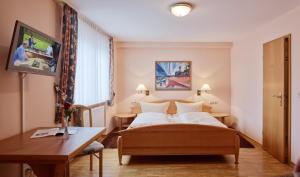 于尔齐希维哥特咖斯德可穆宾馆的配有一张床和一张书桌的酒店客房