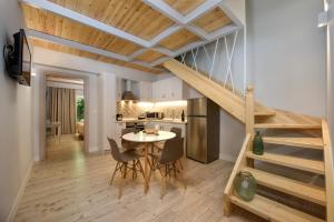 贝尼蔡斯La Soffitta的厨房以及带楼梯和桌子的客厅。