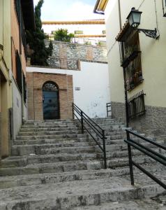 格拉纳达Escapadas romanticas en Granada jacuzzi的通往大楼门的楼梯