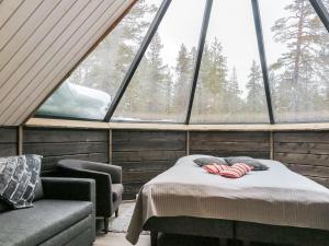 KakslauttanenHoliday Home Arctic light hut by Interhome的客房设有床、沙发和窗户。