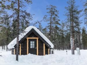 KakslauttanenHoliday Home Arctic light hut by Interhome的屋顶上积雪的小小木屋
