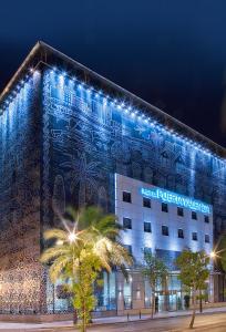 瓦伦西亚西尔肯瓦伦西亚之门酒店的建筑的侧面有蓝色的灯光