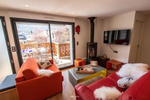 圣拉里苏朗Chalet Hygge Saint Lary - ressourcez-vous dans les Pyrénées的客厅设有2张红色的沙发和壁炉