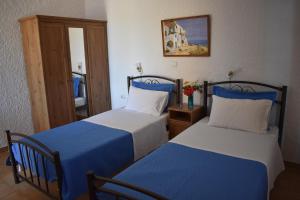 阿吉亚玛丽娜艾瑞克提一室公寓的一间卧室配有两张带蓝白色床单的床