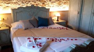 佩雷拉达La Masia de Montpedrós的一间卧室,床上有红色玫瑰