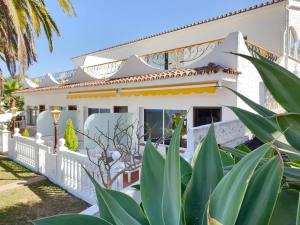 塔科龙特Cosy Well Located Apartment with swimming pool Tenerife的白色的房子,有白色的围栏和棕榈树