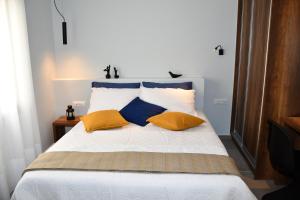 阿基欧斯尼古拉斯So Close!的一间卧室配有黄色和蓝色枕头的床